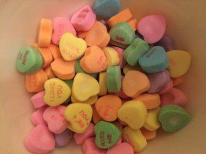 A bunch of candy hearts that are in a bowl