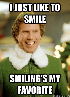 A man in green is smiling for the camera.