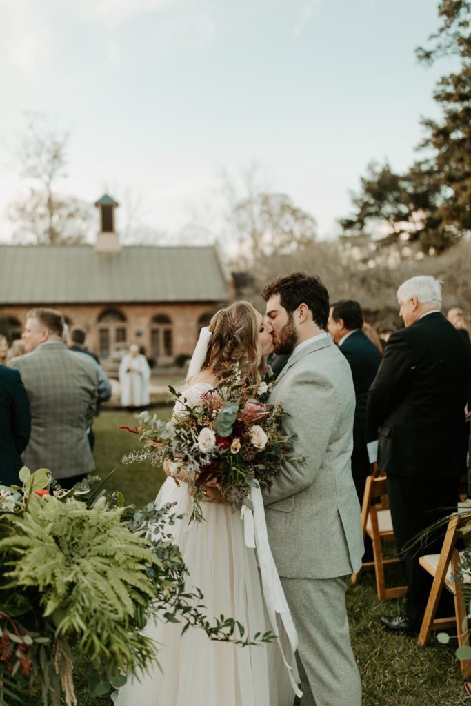 A couple kissing at their wedding ceremony.